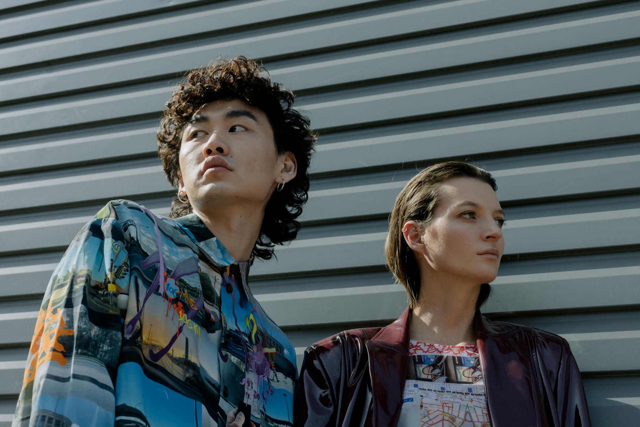 Stylish portrait of a diverse man and woman showcasing contemporary fashion against a sleek background.
